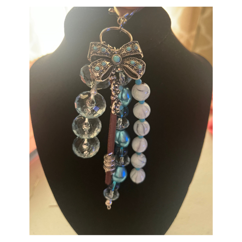Silver bow bag charm with turquoise-colored, pearl and glass beads and leather straps